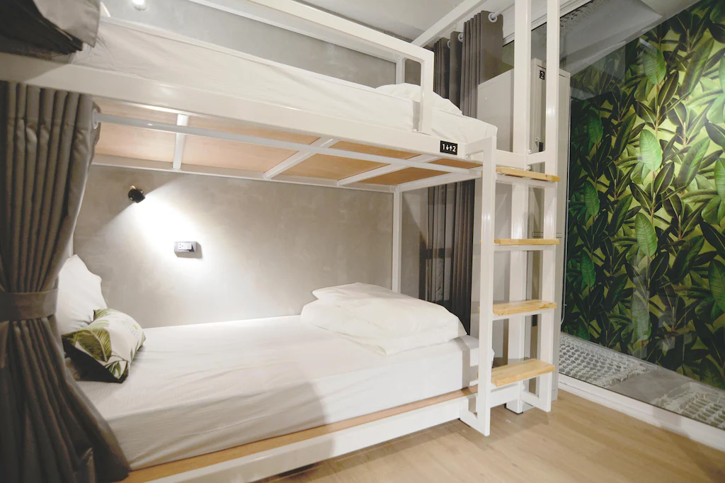 Lower capsule bed with curtain, pillow and leaf-print cushion