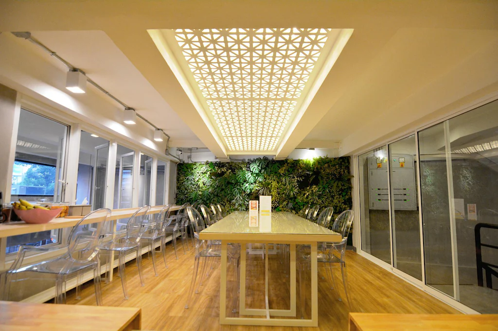 Breakfast room with perforated ceiling light and living plant wall