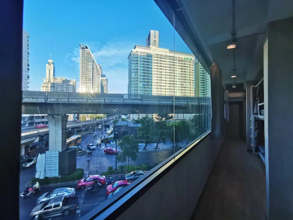 View of the BTS Skytrain and Bangkok skyline from the hostel corridor